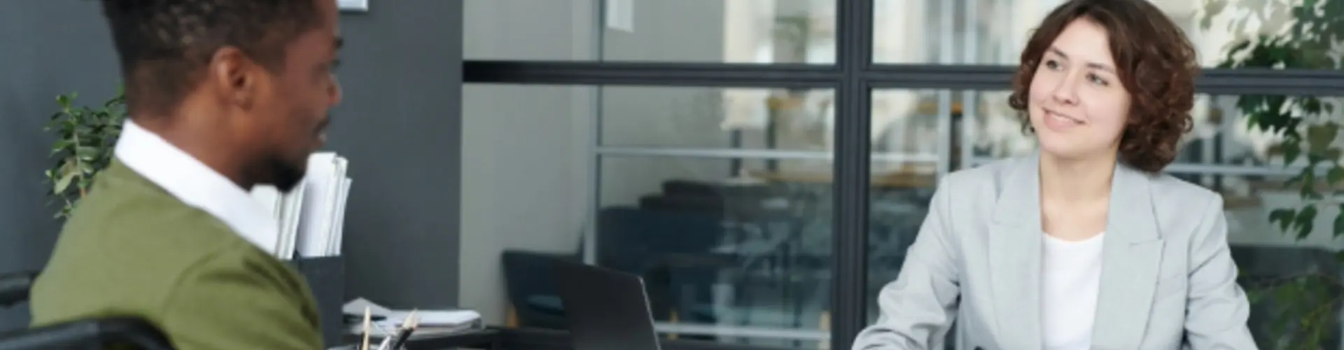 two people chatting in an office meeting room environment