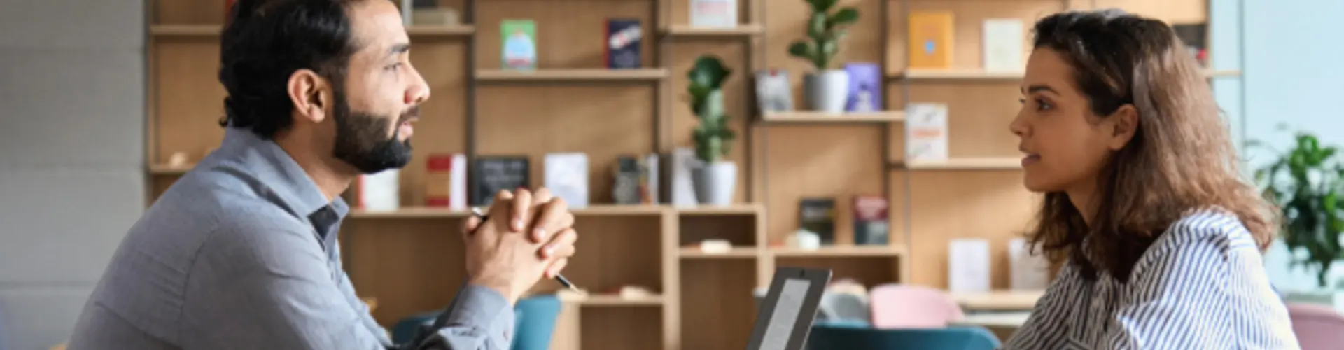 photo of two people talking over a laptop