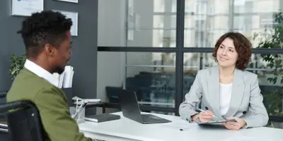 two people chatting in an office meeting room environment