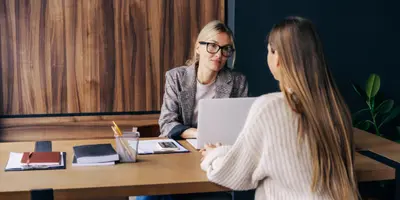 photo of two people chatting over a table