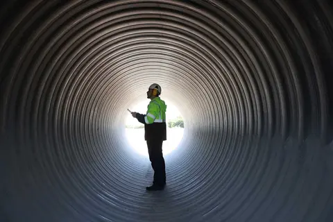 Person in safety gear stood in a large tunnel